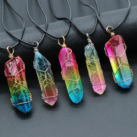 Colorful crystal pendants on black strings against a dark background